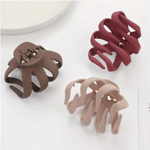 Three matte octopus hair claw clips in burgundy, brown and beige colors on white background