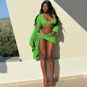 Close-up of green bubble texture knit fabric on a long sleeve crop top and mini skirt set