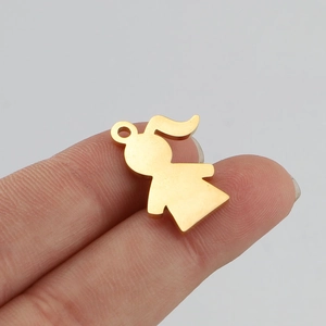 Close-up of a golden stainless steel girl silhouette pendant held by fingers