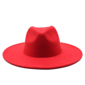 Detailed close-up of bright red wool fedora hat with wide brim and structured crown