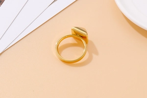 Detail of a bold gold stainless steel ring with a geometric square pyramid top design