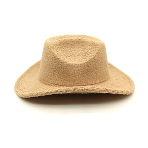 Gros plan d'un chapeau de cow-boy en laine d'agneau camel avec texture bouclée épaisse