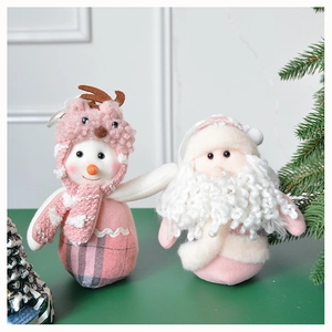 Detailed view of plush Christmas snowman and Santa Claus figurines in pink and white