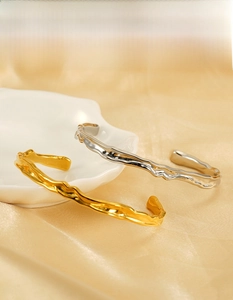Detail of irregular hammered texture on 18K gold and silver stainless steel bangles