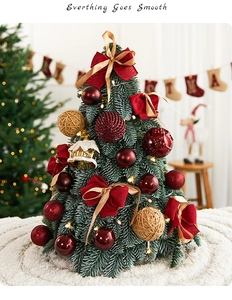 Macro shot of 50cm PE mini Christmas tree with red velvet bows and warm LED lights