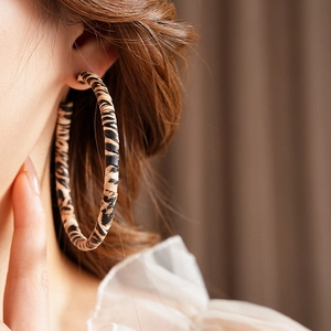 Close-up of vintage large hoop earrings featuring a stylish leopard print fabric wrap