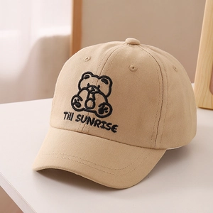 Close-up of the cartoon bear embroidery and Till SUNRISE text on the kids' cotton baseball cap