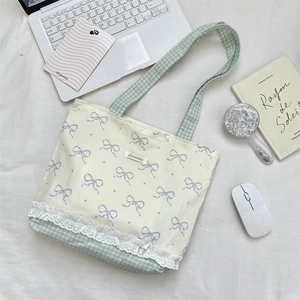 Lace-trimmed canvas tote with blue bows, checkered patterns, and everyday accessories