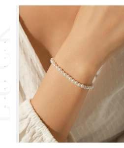 Close-up of elegant s925 silver bracelet with small round pearls on a woman wrist