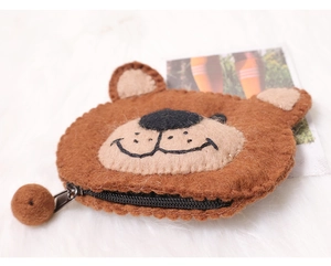 Detail of a brown bear wool felt coin purse featuring a zipper with a small pompom ball