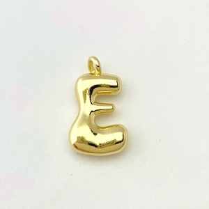 Macro view of a 3D bubble letter E pendant in polished gold finish with a smooth metal surface