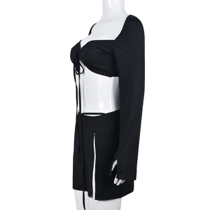Detailed side view of black two-piece set with long sleeve crop top and side slit mini skirt