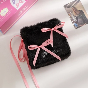 Detail of plush black photo album featuring pink satin bows and embroidered lettering