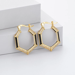 Close-up of gold hexagonal hoop earrings with black inserts and 925 silver hallmark