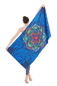 Detail of bohemian mandala print microfiber beach towel held by a model on white background