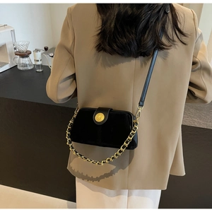 Detailed shot of black velvet doctor bag with vintage gold lion buckle and chain strap