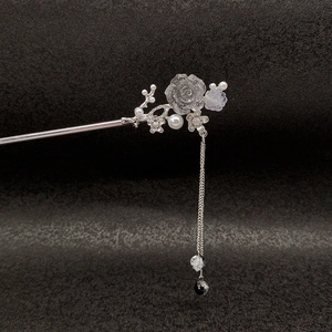 Detail of silver vintage hair stick with translucent rose, pearls, and long tassel