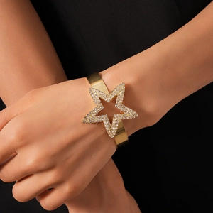 Detailed view of luxury gold cuff bracelet with oversized sparkling rhinestone star