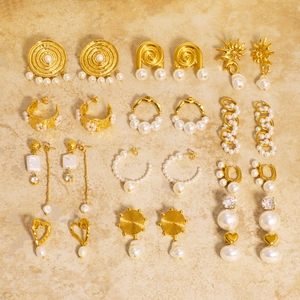 Baroque vintage gold pearl earring set featuring zircons and heart shapes on marble