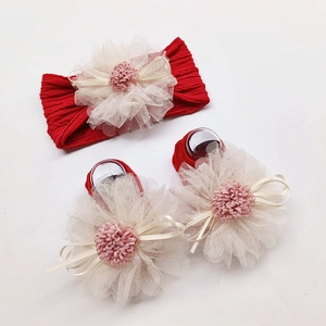 Close-up of red baby headband and socks set with large lace flowers and ribbons