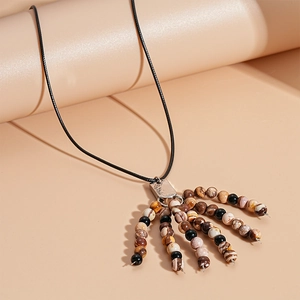 Detail of vintage beaded fringe pendant necklace with natural brown and beige stones