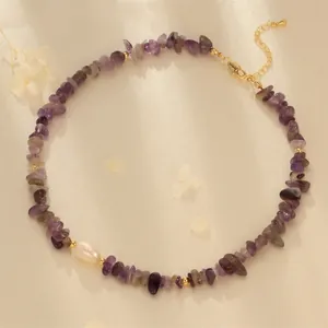 Detail of amethyst gravel necklace with a white pearl on elegant satin fabric