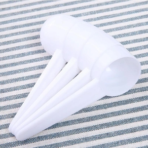 White plastic measuring spoon set for powder and liquid nested on blue striped background