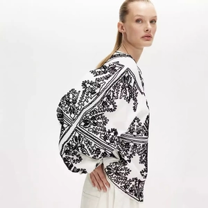Veste blanche pour femme avec broderies noires détaillées et un design à col rond chic