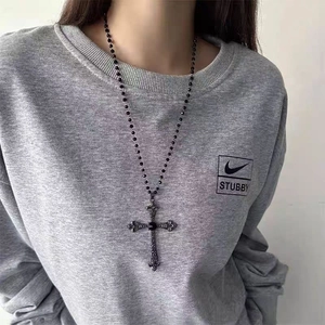 Dark gothic beaded necklace with cross pendant worn by model in a sweet punk style