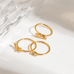 Detailed view of three gold-plated stainless steel rings with sparkling crystals