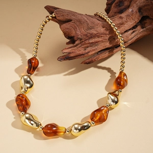 Detailed macro view of amber textured beads and golden irregular metal links on the necklace