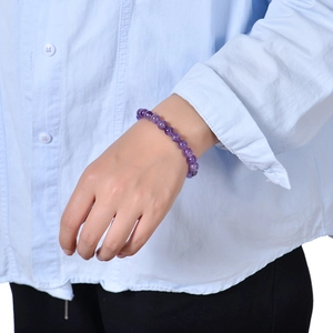 8mm natural amethyst beaded stretch bracelet shown on a model's wrist with blue background