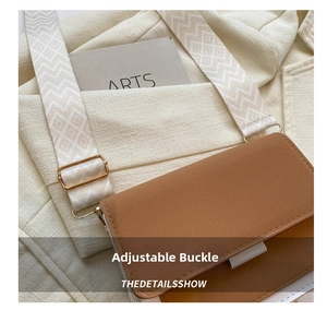 Close-up of adjustable wide jacquard shoulder strap with gold buckle on crossbody bag
