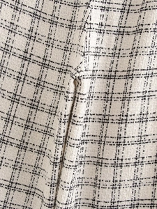 Macro view of black and white tweed fabric texture showing detailed woven plaid patterns