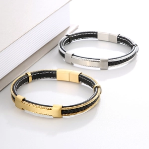 Detail of woven leather bracelets with steel cables in gold and silver finishes