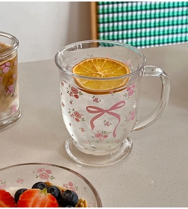Détail d'un mug en verre avec motif nœud rose et tranche d'orange séchée