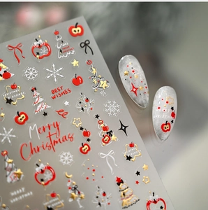 Détail de stickers à ongles de Noël avec motifs pomme rouge, sapin et étoiles