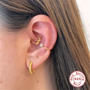 Detail of gold S925 sterling silver ear set with snake hoop, ear cuff, and twisted earring