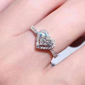 Elegant heart-shaped zircon ring with halo setting and pavé band shown on a hand