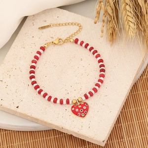 Bohemian beaded bracelet with red heart charm on a natural stone background