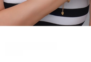 Close-up of gold titanium necklace chain with star pendant and small oval tag detail