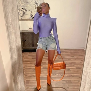 Fashionable purple high neck long sleeve bodysuit with light blue denim shorts and orange boots