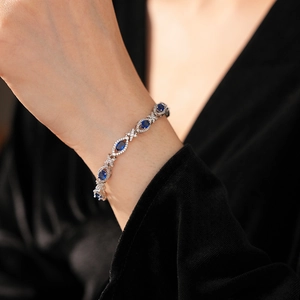 Detail of vintage silver bracelet with oval blue sapphire zircon on a female wrist