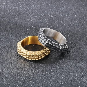 Macro detail of hammered texture and matte finish on gold and silver steel rings