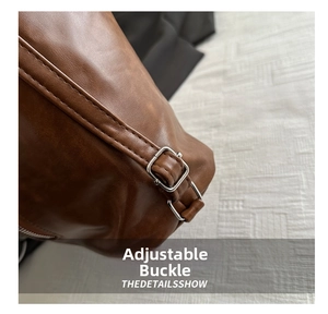 Detail of silver adjustable metal buckle on a retro brown leather tote bag
