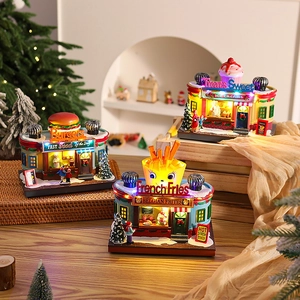 Miniature glowing Christmas village set with LED burger and fries shops on a wooden shelf