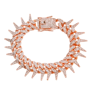 Close-up of rose gold Cuban link bracelet with studded spikes and iced-out crystals
