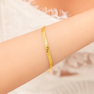 Detailed view of an 18k gold-plated stainless steel snake chain bracelet on a wrist