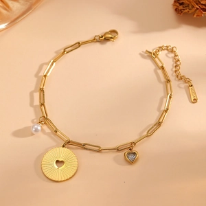 Detail von 18k vergoldetem Titanstahl-Armband mit Herzanhängern und Perlen-Texturen