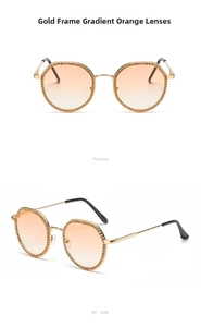 Detail of gold frame sunglasses with rhinestones and orange gradient lenses